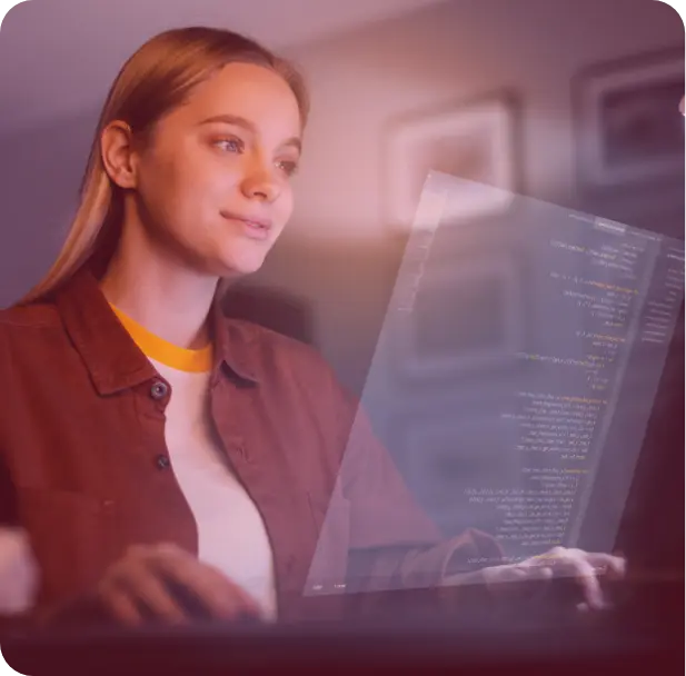 A group of people sitting around a table working on a laptop.